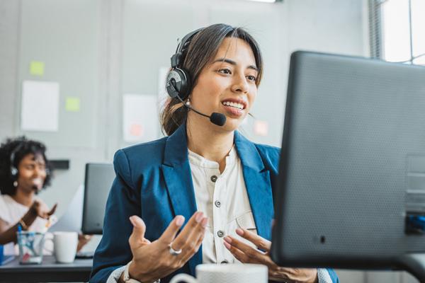 woman in front of computer with headset